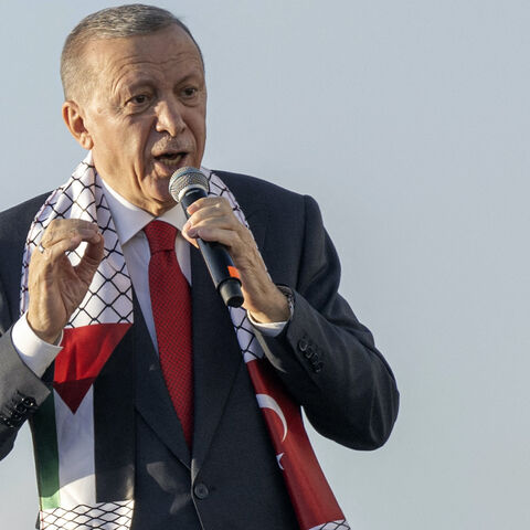 Turkish President Recep Tayyip Erdogan wears a scarf with both Turkish and Palestinian flags as he addresses a rally organized by the AKP party in solidarity with the Palestinians in Gaza, in Istanbul on Oct. 28, 2023. 