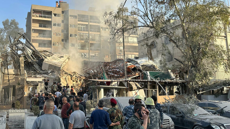 Emergency and security personnel gather at the site of strikes which hit a building next to the Iranian embassy in Syria's capital Damascus, on April 1, 2024. 