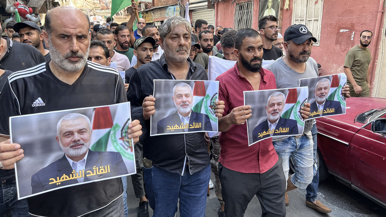 People carry pictures of slain Hamas leader Ismail Haniyeh during a march to condemn his killing, in the Palestinian refugee camp of Ain al-Hilweh, Sidon, Lebanon, July 31, 2024.