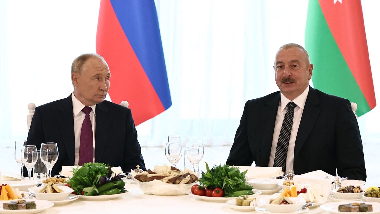 In this pool photograph distributed by Russian state agency Sputnik, Russia's President Vladimir Putin (L) and Azerbaijan's President Ilham Aliyev (R) attend the official dinner following their talks in Baku on August 19, 2024.