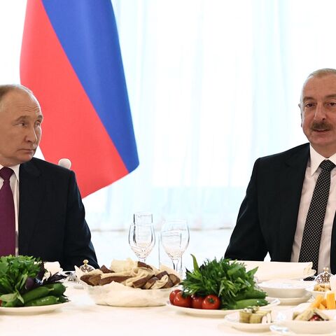 In this pool photograph distributed by Russian state agency Sputnik, Russia's President Vladimir Putin (L) and Azerbaijan's President Ilham Aliyev (R) attend the official dinner following their talks in Baku on August 19, 2024.