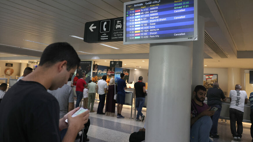 Passengers check their flight times at the Beirut International Airport in Beirut on August 25, 2024, amid escalations in the ongoing cross-border tensions between Hezbollah and Israel. The Beirut airport did not close but some airlines, including Royal Jordanian and Etihad Airways, cancelled flights. (Photo by ANWAR AMRO / AFP) (Photo by ANWAR AMRO/AFP via Getty Images)