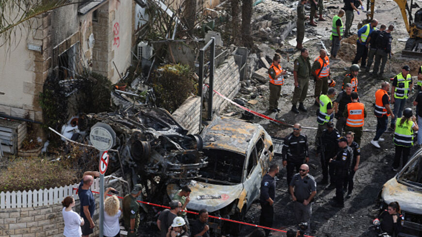 Residents watch as first responders and Israeli security forces gather amid debris and charred vehicles in Kiryat Bialik in the Haifa district of Israel, following a reported strike by Lebanon's Hezbollah on September 22, 2024. Hezbollah said on September 22 that it targeted military production facilities and an air base near north Israel's Haifa after the Israeli military pounded south Lebanon and said it targeted thousands of rocket launcher barrels. (Photo by Jack GUEZ / AFP) (Photo by JACK GUEZ/AFP via 