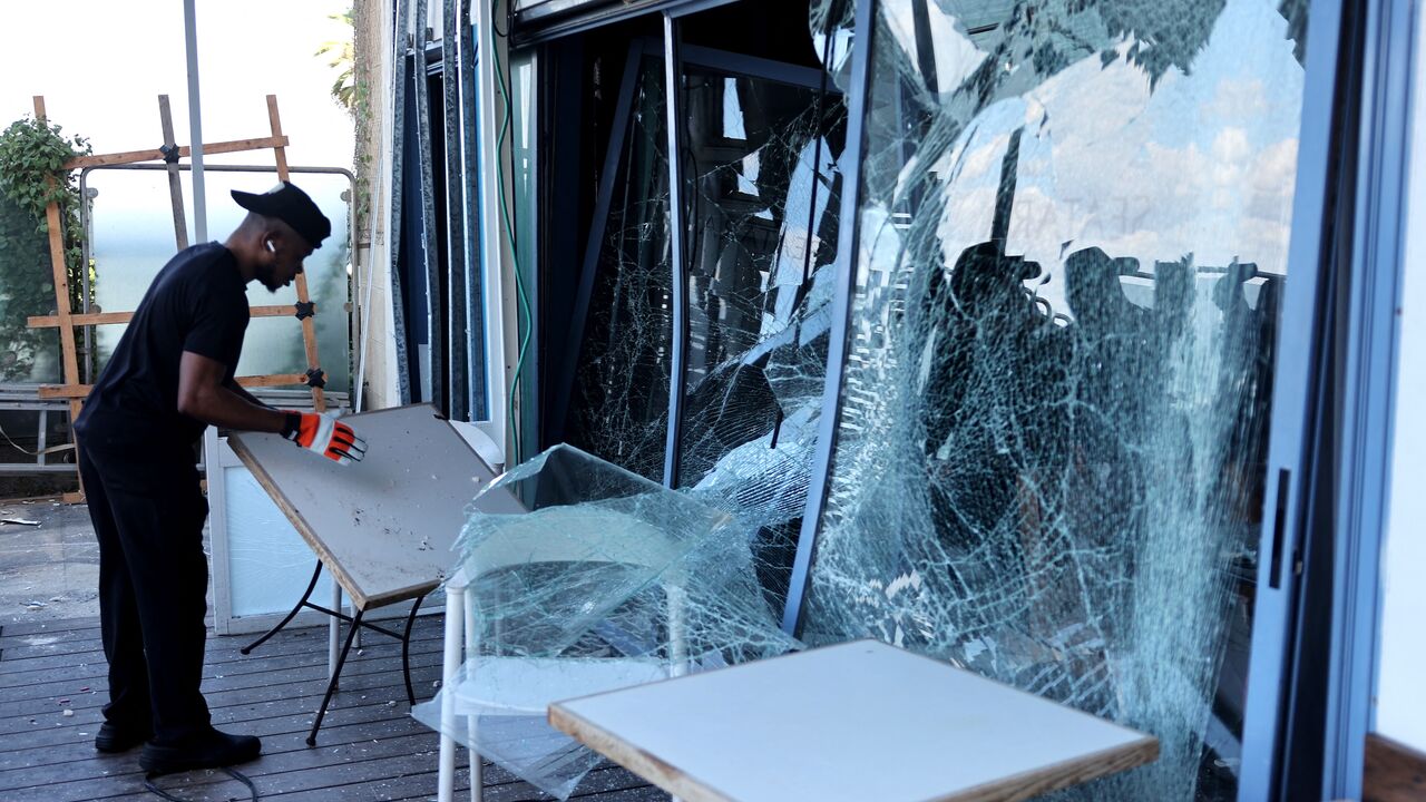 A man checks the damages at a restaurant in the aftermath of an Iranian missile attack on Israel, on Oct. 2, 2024 in Tel Aviv. 