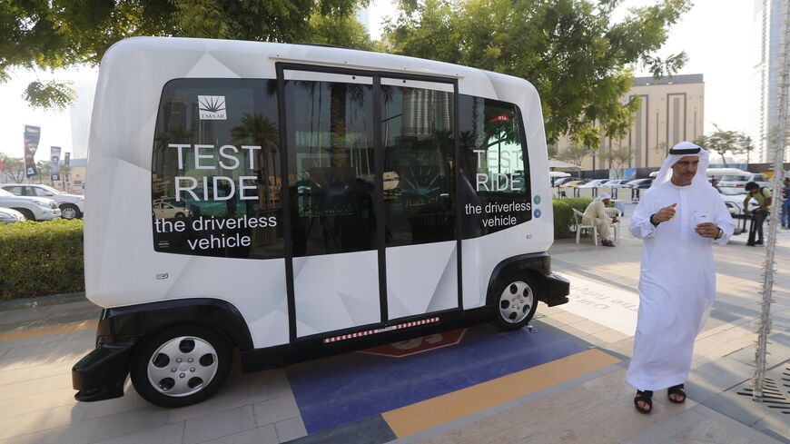 A man walks near an autonomous 10-seater car during a trial run along Mohammed bin Rashid Boulevard on Sept. 1, 2016. 