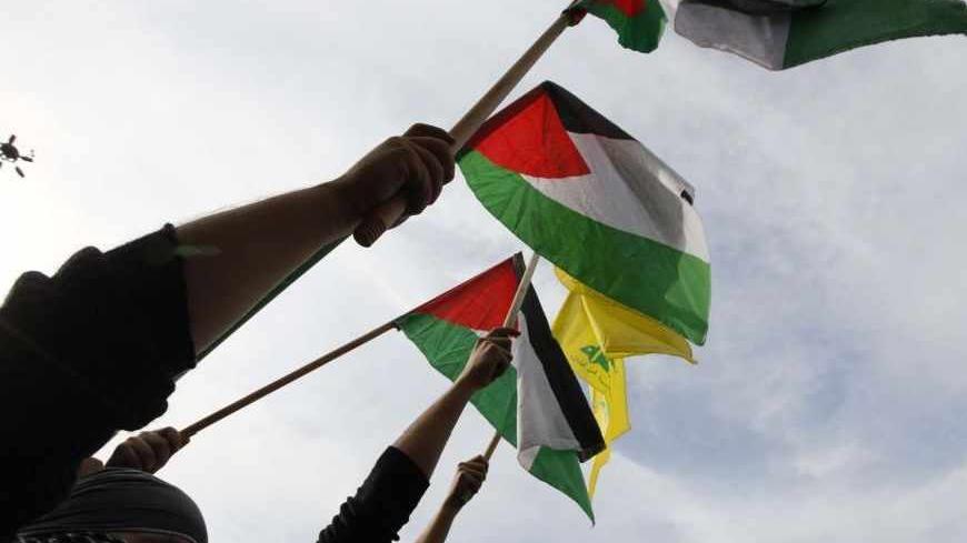 Lebanon's Hezbollah supporters wave Palestinian and Hezbollah flags during a demonstration, organised by Lebanese and Palestinian factions, against Israel's military operation in Gaza, in front of the U.N. headquarters in Beirut November 17, 2012. Israeli aircraft bombed Hamas government buildings in Gaza on Saturday, including the prime minister's office, after Israel's cabinet authorised the mobilisation of up to 75,000 reservists, preparing for a possible ground invasion. REUTERS/Jamal Saidi (LEBANON - T