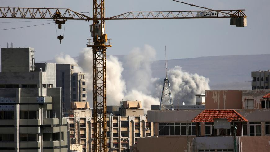 A construction crane is seen as smoke rises from Yarmouk Palestinian camp in Damascus, Syria April 21, 2018. REUTERS/Ali Hashisho - RC16C2D4AC60