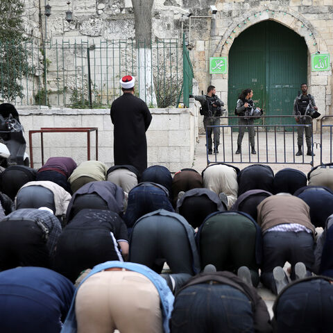 Palestinians pray as Israeli border police stand guard near the entrance door leading to the compound housing al-Aqsa Mosque in Jerusalem's Old City March 12, 2019. REUTERS/Ammar Awad - RC1CD60A6C60